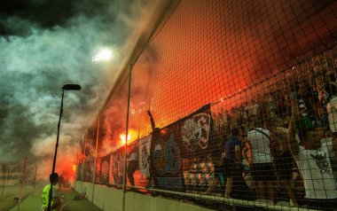 Odessa, Ukrayna-July2, 2018: fanatik hayranları standları ebedi rakip oyun sırasında. Raflar taraftarlara mutlu, yangın ve dalgalanan bayrak ile kızdırma. Ateşli gösteri Stadyumu'nda. Holigan hafif ateşli flashe hayranları