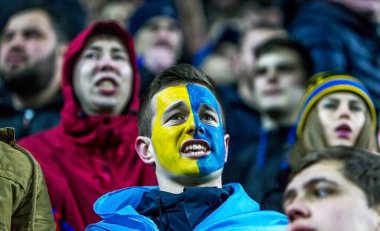 Odessa, Ukrayna - 24 Mart 2016: Futbol taraftarları ve seyirci stadyum standları duygusal onların Ukrayna ve Kıbrıs Milli takım maç sırasında destek ekibi. Duygular, el fenerleri, duman, çığlıkları