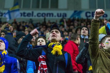 Odessa, Ukrayna - 24 Mart 2016: Futbol taraftarları ve seyirci stadyum standları duygusal onların Ukrayna ve Kıbrıs Milli takım maç sırasında destek ekibi. Duygular, el fenerleri, duman, çığlıkları