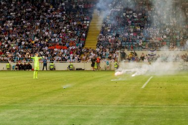 Odessa, Ukrayna - Temmuz 15,2017: Foxtrot süper kupa. Madenci - Dinamo. Fanatik heyecanlı hayranları ile havai fişek. Taraftar standları yanık yangında sevinirler ve çırpmaya başlar. Petards stadyum alanında oyun parçaladı