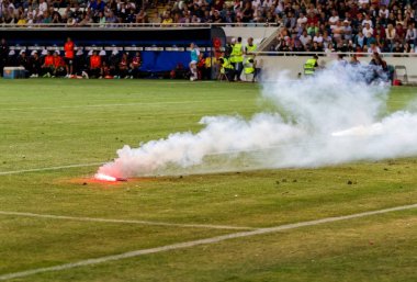 Odessa, Ukrayna - Temmuz 15,2017: Foxtrot süper kupa. Madenci - Dinamo. Fanatik heyecanlı hayranları ile havai fişek. Taraftar standları yanık yangında sevinirler ve çırpmaya başlar. Petards stadyum alanında oyun parçaladı