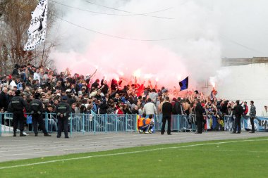 Odessa, Ukraine - November 14, 2010: Ultras emotional football fans during the game for his club Chernomorets rioted with police, broken rostrum, fights, fireworks on the playing field clipart