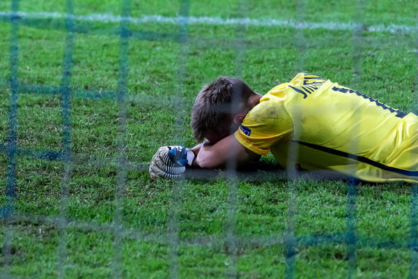 ODESSA, UKRAINE - September 15, 2016: Zarya FC goalkeeper Andrei Lunin reacts emotionally to the missed goal. The goalkeeper lies on the football field after the goal scored in the goal