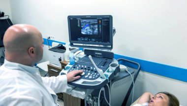 Odessa, Ukrayna - 29 Temmuz 2018: Kadın muayene damarların ultrason sensör modern teknoloji Kliniği üzerinde uğrar. Damarlar ve doppler incelenmesi monitör durumu