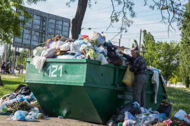 Odessa, Ukrayna - Cirka 2018: Yemek atıkları, teneke ve plastik şişe ve plastik torbalar çöp yığını bir kalabalık kapsayıcıdan dağınık olduğunu. Çöple dolu çöp konteyneri