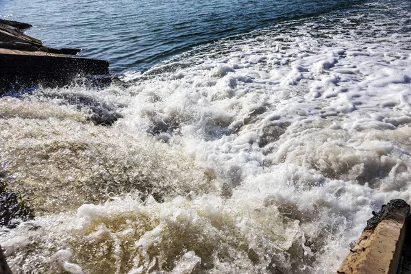 Dirty waste water from the municipal sewer openly merge into the marine estuary. Wastewater treatment plants. The environmental problem of environmental pollution.