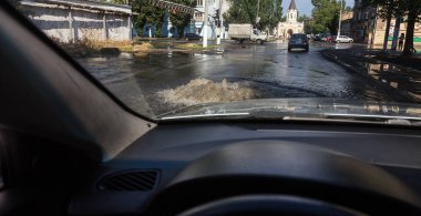 Odessa, Ukrayna -3 Temmuz 2018: yağmur fırtına tarafından neden olduğu sel sırasında su dolu bir yolda araba sürmek. Arabalar sokaklarda sel su üzerinde yüzer. Sıçramak üstünde belgili tanımlık makine. Büyük bir su birikintisi olan sular altında şehir yol