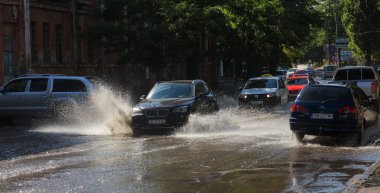 Odessa, Ukrayna -3 Temmuz 2018: yağmur fırtına tarafından neden olduğu sel sırasında su dolu bir yolda araba sürmek. Arabalar sokaklarda sel su üzerinde yüzer. Sıçramak üstünde belgili tanımlık makine. Büyük bir su birikintisi olan sular altında şehir yol