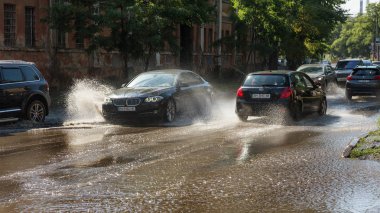 Odessa, Ukrayna -3 Temmuz 2018: yağmur fırtına tarafından neden olduğu sel sırasında su dolu bir yolda araba sürmek. Arabalar sokaklarda sel su üzerinde yüzer. Sıçramak üstünde belgili tanımlık makine. Büyük bir su birikintisi olan sular altında şehir yol
