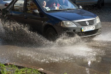 Odessa, Ukrayna -3 Temmuz 2018: yağmur fırtına tarafından neden olduğu sel sırasında su dolu bir yolda araba sürmek. Arabalar sokaklarda sel su üzerinde yüzer. Sıçramak üstünde belgili tanımlık makine. Büyük bir su birikintisi olan sular altında şehir yol