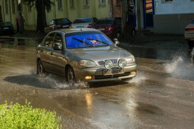 Odessa, Ukrayna -3 Temmuz 2018: yağmur fırtına tarafından neden olduğu sel sırasında su dolu bir yolda araba sürmek. Arabalar sokaklarda sel su üzerinde yüzer. Sıçramak üstünde belgili tanımlık makine. Büyük bir su birikintisi olan sular altında şehir yol