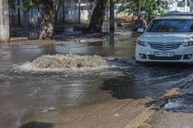 Odessa, Ukrayna -3 Temmuz 2018: yağmur fırtına tarafından neden olduğu sel sırasında su dolu bir yolda araba sürmek. Arabalar sokaklarda sel su üzerinde yüzer. Sıçramak üstünde belgili tanımlık makine. Büyük bir su birikintisi olan sular altında şehir yol