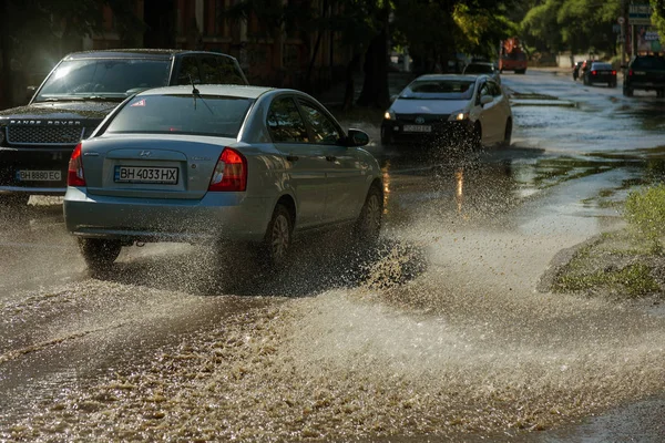 Odessa, Ukrayna -3 Temmuz 2018: yağmur fırtına tarafından neden olduğu sel sırasında su dolu bir yolda araba sürmek. Arabalar sokaklarda sel su üzerinde yüzer. Sıçramak üstünde belgili tanımlık makine. Büyük bir su birikintisi olan sular altında şehir yol
