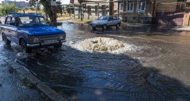Odessa, Ukrayna -3 Temmuz 2018: yağmur fırtına tarafından neden olduğu sel sırasında su dolu bir yolda araba sürmek. Arabalar sokaklarda sel su üzerinde yüzer. Sıçramak üstünde belgili tanımlık makine. Büyük bir su birikintisi olan sular altında şehir yol
