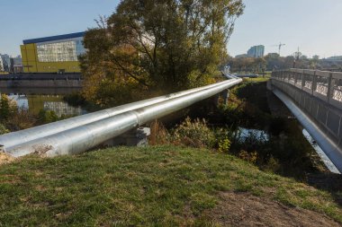 Modern ısı boruları yüksek. Isı-sıcaklık şehir iletken zemin, boru hattı yukarıda. Şehir yerleşim Mahallesi metal yalıtımında Kentsel ısı hattı. Sütun üzerine döşeme açın. Belediye ısı kaynağı