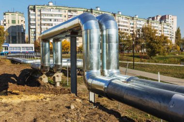 Modern ısı boruları yüksek. Isı-sıcaklık şehir iletken zemin, boru hattı yukarıda. Şehir yerleşim Mahallesi metal yalıtımında Kentsel ısı hattı. Sütun üzerine döşeme açın. Belediye ısı kaynağı