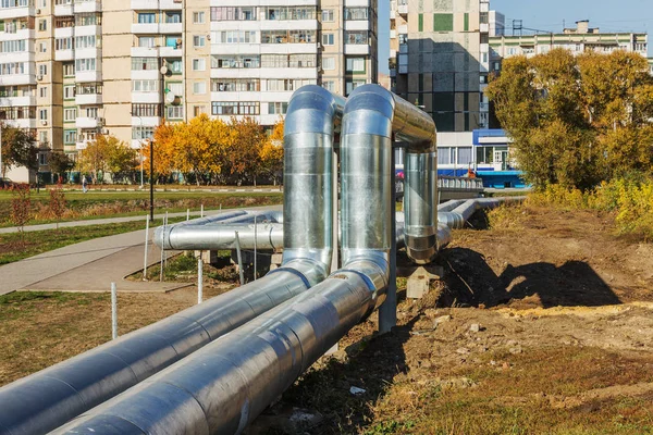 Modern Elevated Heat Pipes. Pipeline above ground, conducting heat to heat city. Urban heat line in metal insulation in residential quarter of city. Open laying on pillars. Municipal heat supply