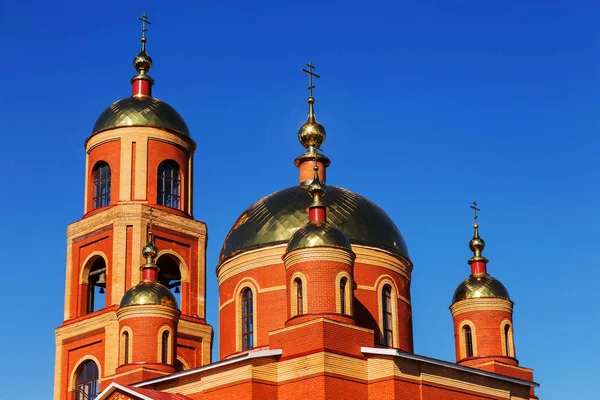 Russian Orthodox Church on the background of blue sunny sky. Orthodox church golden domes and crosses. Church of the New Martyrs and Confessors of Belgorod. Belgorod, Russia 2018