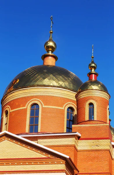 Russian Orthodox Church on the background of blue sunny sky. Orthodox church golden domes and crosses. Church of the New Martyrs and Confessors of Belgorod. Belgorod, Russia 2018