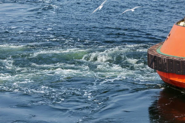 Track on the surface of the sea water behind the cargo sea ship. Trail on the surface of the water behind the speedboat. Sea wave trail on the surface, whirlpool, wave turbulence