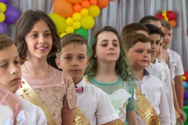 Odessa, Ukrayna - 31,2018 olabilir: Çocuk müzikal grup şarkı ve sahne alanı'nda İlköğretim Okulu mezuniyet konser sırasında dans. Çocuk oyun. Duygusal çocuk göstermek sahnede. Çocukların yaratıcılık