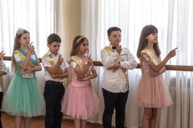 Odessa, Ukrayna - 31,2018 olabilir: Çocuk müzikal grup şarkı ve sahne alanı'nda İlköğretim Okulu mezuniyet konser sırasında dans. Çocuk oyun. Duygusal çocuk göstermek sahnede. Çocukların yaratıcılık