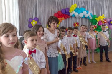 Odessa, Ukrayna - 31,2018 olabilir: Çocuk müzikal grup şarkı ve sahne alanı'nda İlköğretim Okulu mezuniyet konser sırasında dans. Çocuk oyun. Duygusal çocuk göstermek sahnede. Çocukların yaratıcılık