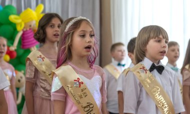 Odessa, Ukrayna - 31,2018 olabilir: Çocuk müzikal grup şarkı ve sahne alanı'nda İlköğretim Okulu mezuniyet konser sırasında dans. Çocuk oyun. Duygusal çocuk göstermek sahnede. Çocukların yaratıcılık