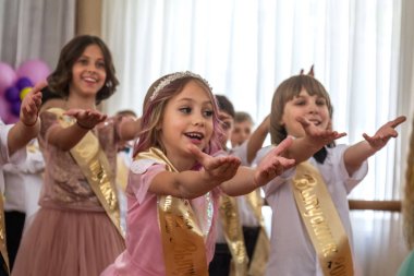 Odessa, Ukrayna - 31,2018 olabilir: Çocuk müzikal grup şarkı ve sahne alanı'nda İlköğretim Okulu mezuniyet konser sırasında dans. Çocuk oyun. Duygusal çocuk göstermek sahnede. Çocukların yaratıcılık