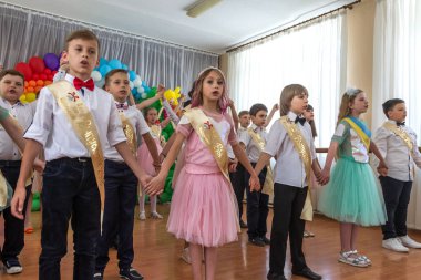 Odessa, Ukrayna - 31,2018 olabilir: Çocuk müzikal grup şarkı ve sahne alanı'nda İlköğretim Okulu mezuniyet konser sırasında dans. Çocuk oyun. Duygusal çocuk göstermek sahnede. Çocukların yaratıcılık