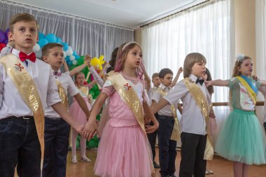 Odessa, Ukrayna - 31,2018 olabilir: Çocuk müzikal grup şarkı ve sahne alanı'nda İlköğretim Okulu mezuniyet konser sırasında dans. Çocuk oyun. Duygusal çocuk göstermek sahnede. Çocukların yaratıcılık