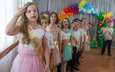 Odessa, Ukrayna - 31,2018 olabilir: Çocuk müzikal grup şarkı ve sahne alanı'nda İlköğretim Okulu mezuniyet konser sırasında dans. Çocuk oyun. Duygusal çocuk göstermek sahnede. Çocukların yaratıcılık