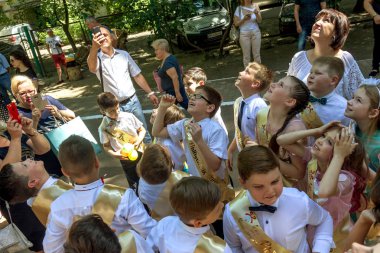 Odessa, Ukrayna - 31,2018 olabilir: Çocuk müzikal grup şarkı ve sahne alanı'nda İlköğretim Okulu mezuniyet konser sırasında dans. Çocuk oyun. Duygusal çocuk göstermek sahnede. Çocukların yaratıcılık