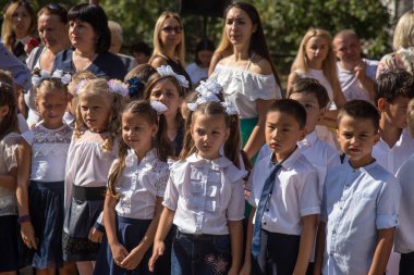 Odessa, Ukrayna 1 Eylül 2018: Eylül 1 gün kutlama bilgi. Gülümseyen mutlu birinci sınıf öğrencileri ve velileri mutlu. Okul içinde öğretmen eğitim yılın başında tatil