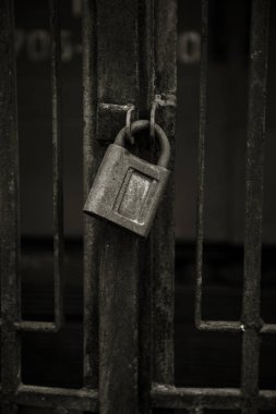 Kavramsal bir eski vintage paslı kapalı kilit paslı geçit üzerinde fotoğrafını ızgara. Antika Antika paslı asma kilit bir arka plan üzerinde. Antika paslı asma kilit kilit kapalı. Büyük eski kilit bu kapıyı kapatır
