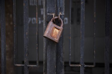 Kavramsal bir eski vintage paslı kapalı kilit paslı geçit üzerinde fotoğrafını ızgara. Antika Antika paslı asma kilit bir arka plan üzerinde. Antika paslı asma kilit kilit kapalı. Büyük eski kilit bu kapıyı kapatır