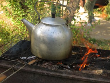Eski su ısıtıcısı ve güneş ışığı eski füme su ısıtıcısı duman. Kaynar su ve çay üzerinde kamp kamp gezisi sırasında Vintage Turizm arka plan yapmak için eski bir geleneksel alüminyum çaydanlık Turistik arka plan olduğunu