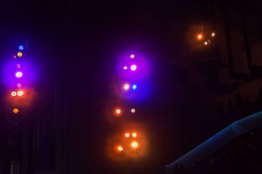 Sahne ışıkları. Karanlıkta birkaç projektör var. Gösteri sırasında sahnenin sahne ışıklarından gelen çok renkli ışık demetleri sahnenin dumanının içinde. Gece kulübü. Işıklar açık. Lazer gösterisi