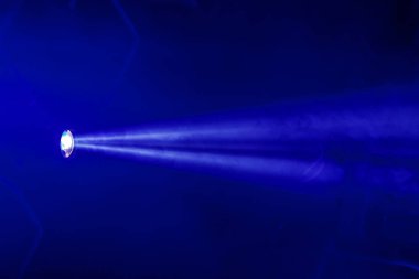 Sahne ışıkları. Karanlıkta birkaç projektör var. Gösteri sırasında sahnenin sahne ışıklarından gelen çok renkli ışık demetleri sahnenin dumanının içinde. Gece kulübü. Işıklar açık. Lazer gösterisi