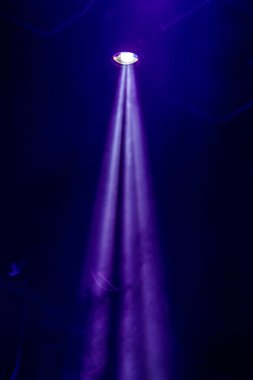 Sahne ışıkları. Karanlıkta birkaç projektör var. Gösteri sırasında sahnenin sahne ışıklarından gelen çok renkli ışık demetleri sahnenin dumanının içinde. Gece kulübü. Işıklar açık. Lazer gösterisi