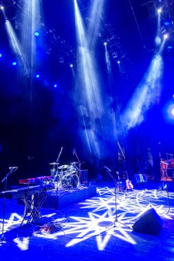 Sahne ışıkları. Karanlıkta birkaç projektör var. Gösteri sırasında sahnenin sahne ışıklarından gelen çok renkli ışık demetleri sahnenin dumanının içinde. Gece kulübü. Işıklar açık. Lazer gösterisi