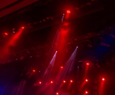 Sahne ışıkları. Karanlıkta birkaç projektör var. Gösteri sırasında sahnenin sahne ışıklarından gelen çok renkli ışık demetleri sahnenin dumanının içinde. Gece kulübü. Işıklar açık. Lazer gösterisi