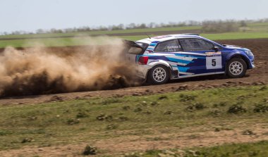 ODESSA, UKRAINE - 30 Nisan 2017: Geleneksel ralli Autocross Şampiyonası. Yarış arabası tehlikeli. Dik bir yarış pistine giriyor, etrafa saçılıyor, toz püskürtüyor. Aşırı ralli otomobili