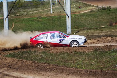 ODESSA, UKRAINE - 30 Nisan 2017: Geleneksel ralli Autocross Şampiyonası. Yarış arabası tehlikeli. Dik bir yarış pistine giriyor, etrafa saçılıyor, toz püskürtüyor. Aşırı ralli otomobili