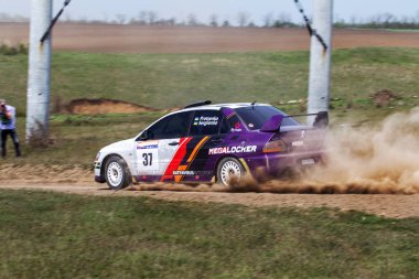 ODESSA, UKRAINE - 30 Nisan 2017: Geleneksel ralli Autocross Şampiyonası. Yarış arabası tehlikeli. Dik bir yarış pistine giriyor, etrafa saçılıyor, toz püskürtüyor. Aşırı ralli otomobili