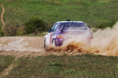 ODESSA, UKRAINE - 30 Nisan 2017: Geleneksel ralli Autocross Şampiyonası. Yarış arabası tehlikeli. Dik bir yarış pistine giriyor, etrafa saçılıyor, toz püskürtüyor. Aşırı ralli otomobili
