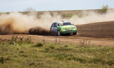 ODESSA, UKRAINE - 30 Nisan 2017: Geleneksel ralli Autocross Şampiyonası. Yarış arabası tehlikeli. Dik bir yarış pistine giriyor, etrafa saçılıyor, toz püskürtüyor. Aşırı ralli otomobili