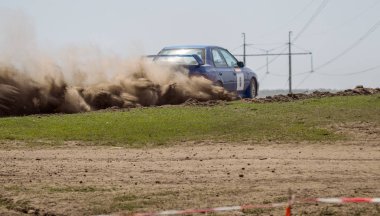 ODESSA, UKRAINE - 30 Nisan 2017: Geleneksel ralli Autocross Şampiyonası. Yarış arabası tehlikeli. Dik bir yarış pistine giriyor, etrafa saçılıyor, toz püskürtüyor. Aşırı ralli otomobili