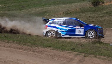 ODESSA, UKRAINE - 30 Nisan 2017: Geleneksel ralli Autocross Şampiyonası. Yarış arabası tehlikeli. Dik bir yarış pistine giriyor, etrafa saçılıyor, toz püskürtüyor. Aşırı ralli otomobili