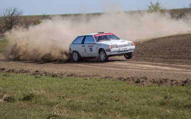 ODESSA, UKRAINE - 30 Nisan 2017: Geleneksel ralli Autocross Şampiyonası. Yarış arabası tehlikeli. Dik bir yarış pistine giriyor, etrafa saçılıyor, toz püskürtüyor. Aşırı ralli otomobili
